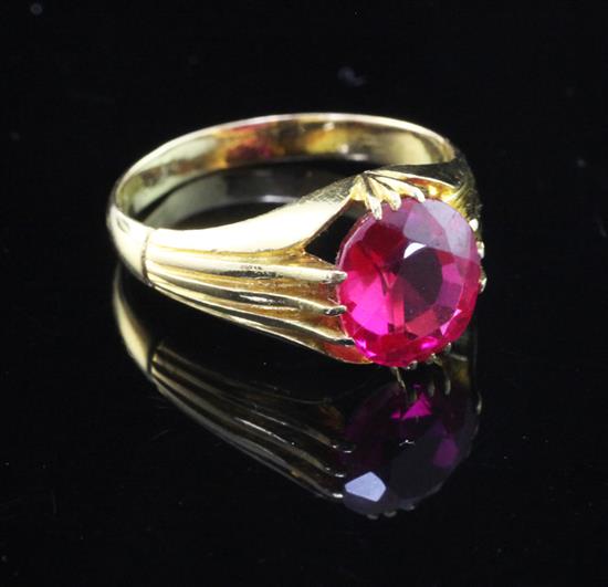 An early/mid 20th century gold and solitaire synthetic ruby claw set ring, size S.